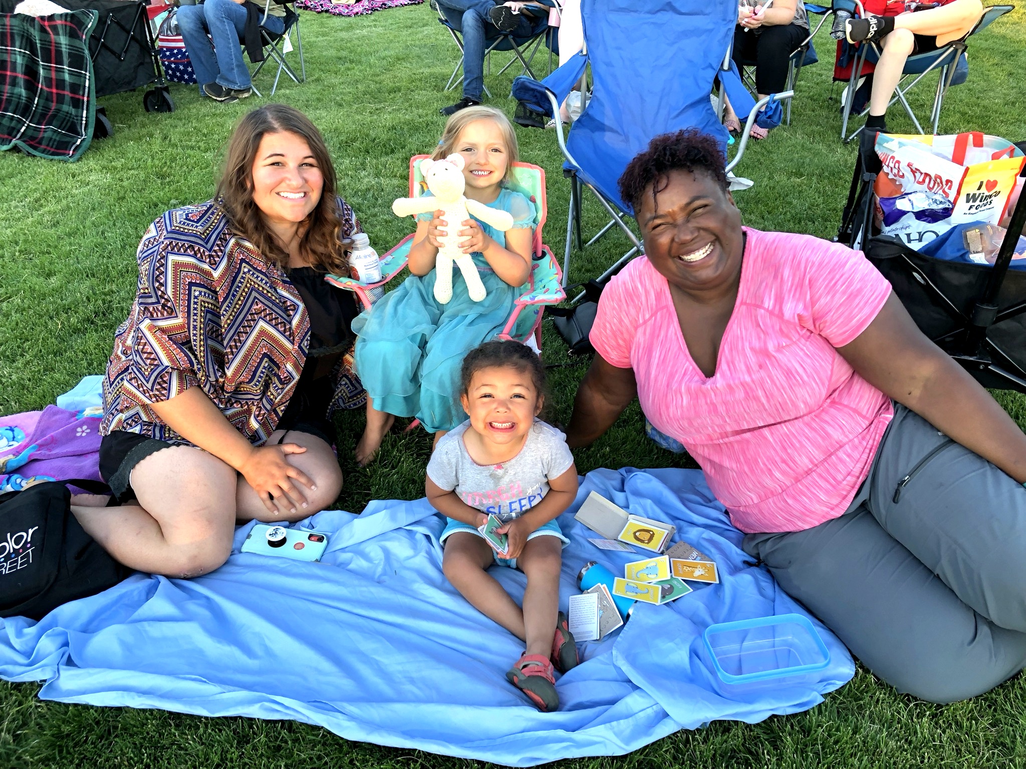 Two women and two kids on blankets at Movie Night
